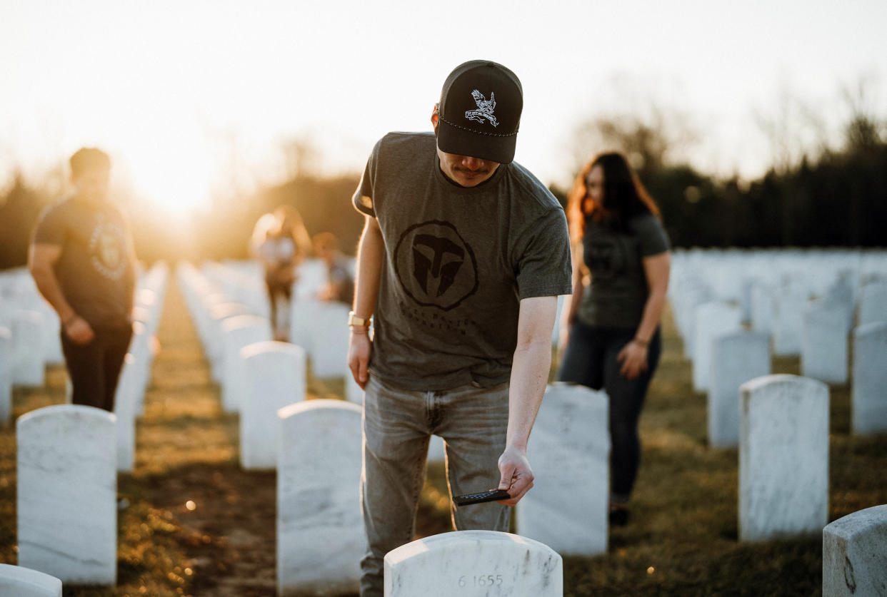 A volunteer pays respects to a fallen soldier as part of 