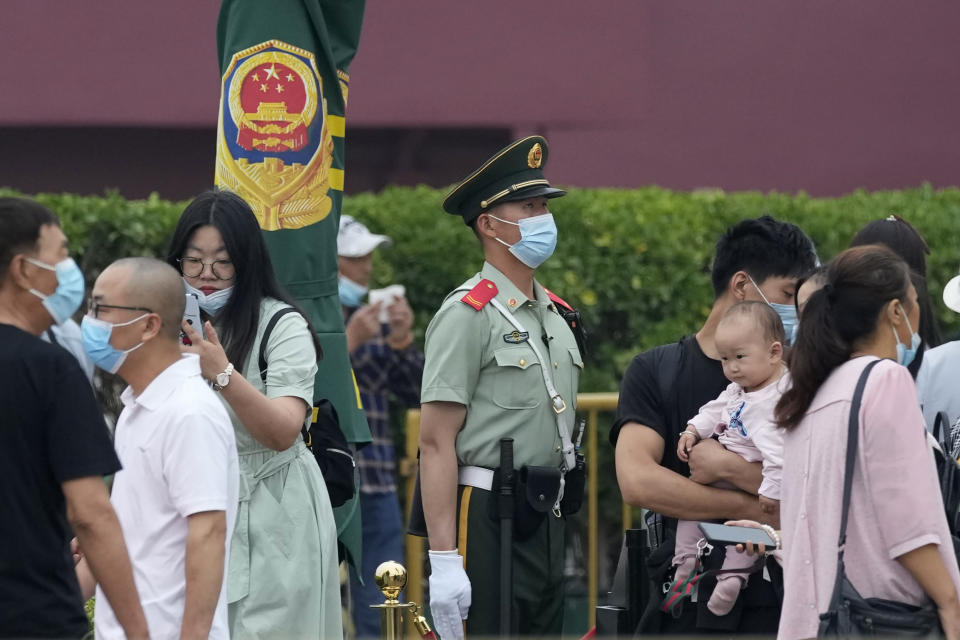 A paramilitary police officer stands guard as visitors pass near the Tiananmen Gate in Beijing on Wednesday, June 2, 2021. Communist Party leaders have imprisoned or driven activists into exile and largely succeeded in ensuring young people know little about the June 4, 1989, deadly crackdown on the pro-democracy movement. But after three changes of leadership since then, they are relentless in trying to prevent any mention of the military attack that killed hundreds and possibly thousands of people. (AP Photo/Ng Han Guan)