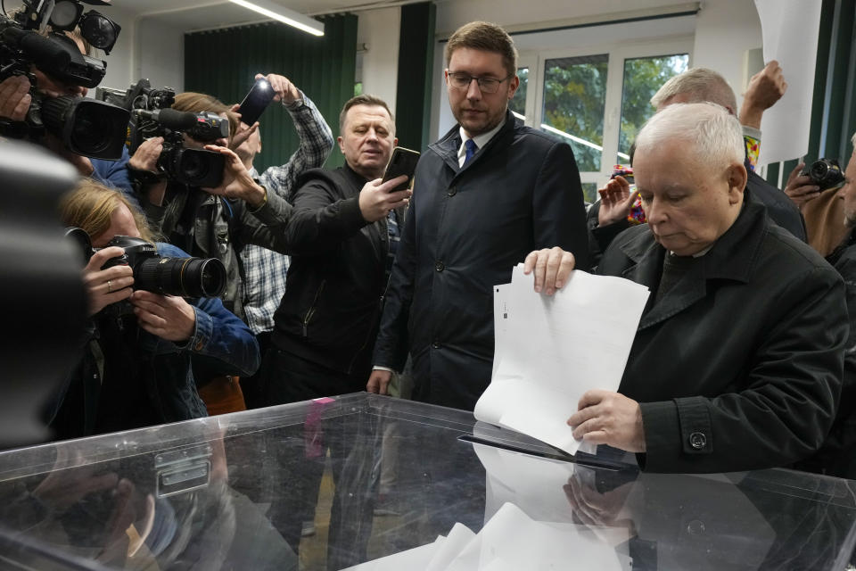 Poland's conservative ruling Law and Justice party leader Jaroslaw Kaczynski, right, casts his ballot at a polling station during parliamentary elections in Warsaw, Poland, Sunday, Oct. 15, 2023. Poland is holding a high-stakes election on Sunday that has energized many voters, with the ruling conservative nationalist party pitted against opposition groups that accuse it of eroding the foundations of the democratic system. (AP Photo/Czarek Sokolowski)