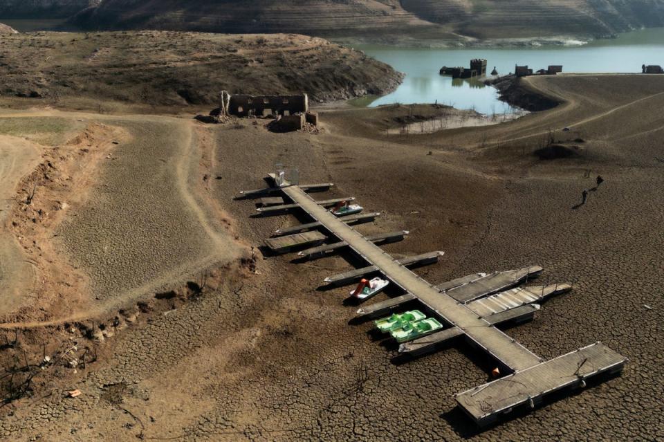 A pier and boats on the dry banks of the depleted Sau reservoir in Girona, Catalonia (AFP via Getty Images)