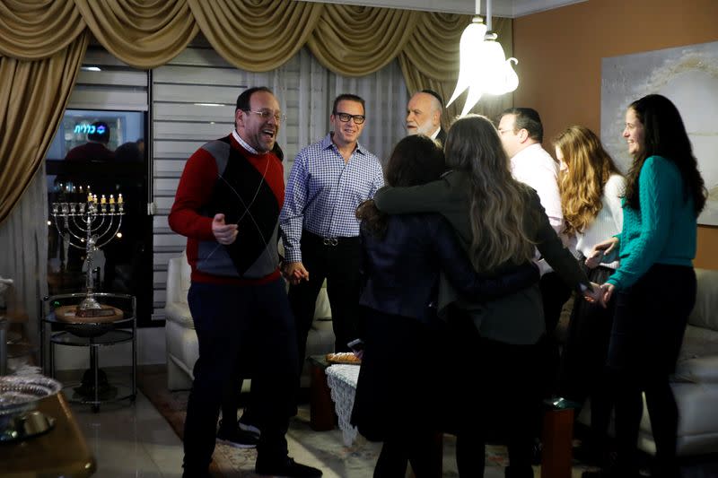 Members of the Shainfeld family gather after lighting a hanukkiyah, a candlestick with nine branches that is lit to mark Hanukkah, the 8-day Jewish Festival of Lights, in Ramat Gan, Israel