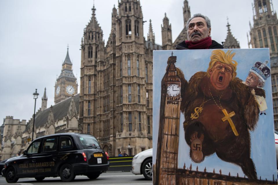 Artist Kaya Mar holds his latest political satire painting of Donald Trump depicted as King Kong with Queen Elizabeth II climbing Elizabeth Tower, commonly known as Big Ben just after Prime Minister Theresa May announced President Trump would be making a visit.