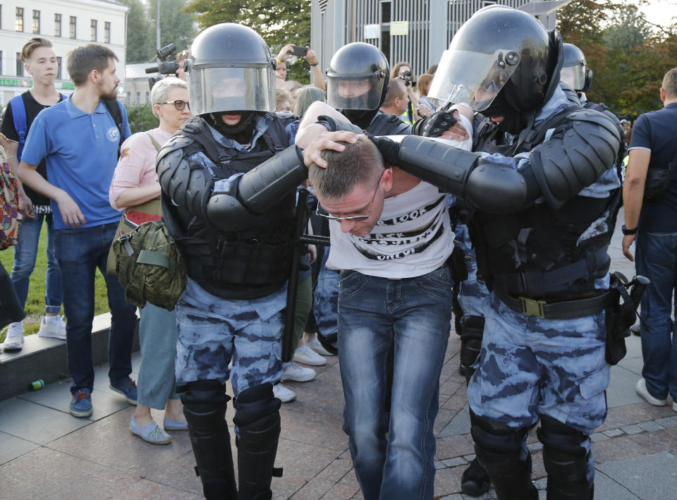 Police officers detain a man during an unsanctioned rally in the centre of Moscow, Russia, Saturday, July 27, 2019. Russian police have clashed with demonstrators and have arrested some hundreds in central Moscow during a protest demanding that opposition candidates be allowed to run for the Moscow city council. (AP Photo/Alexander Zemlianichenko)