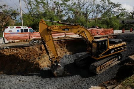 A crane is seen inside a sinkhole caused by Hurricane Maria at a construction site along Puerto Rico Highway 2, outside San Juan, Puerto Rico, October 12, 2017. REUTERS/Shannon Stapleton