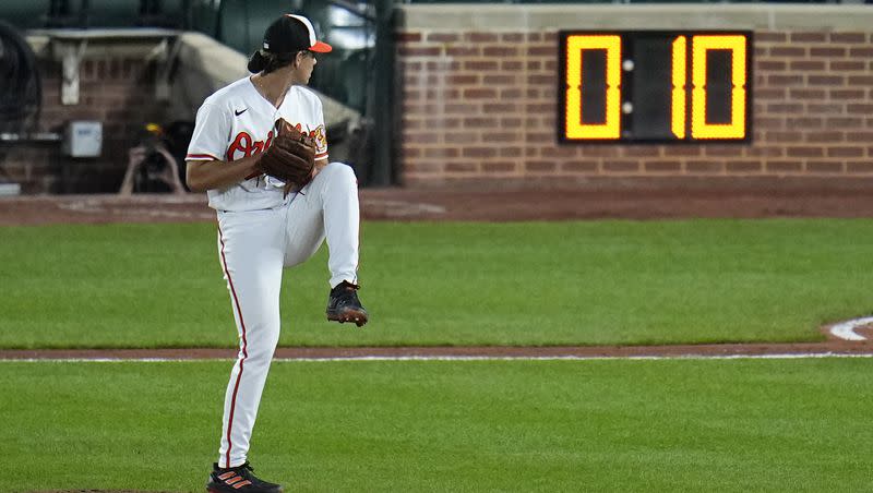 The pitch clock is visible as Baltimore Orioles starting pitcher Dean Kremer winds up to deliver during the sixth inning of a MLB game against the Boston Red Sox, April 24, 2023, in Baltimore, Md. Limits on infield shifts, a pitch clock and larger bases were implemented this year in an attempt to counter the impact of the analytics era suffocation of offense.