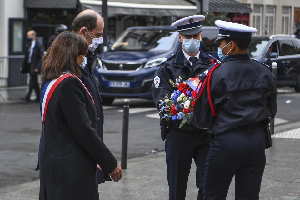 Paris Mayor Anne Hidalgo, left, and French Prime Minister Jean Castex participate in a wreath laying ceremony, marking the 5th anniversary of the Nov. 13, 2015 attacks outside the Carillon bar and the Petit Cambodge restaurant in Paris, Friday, Nov. 13, 2020. In silence and mourning, France is marking five years since 130 people were killed by Islamic State extremists who targeted the Bataclan concert hall, Paris cafes and the national stadium. (Christophe Archambault/Pool Photo via AP)