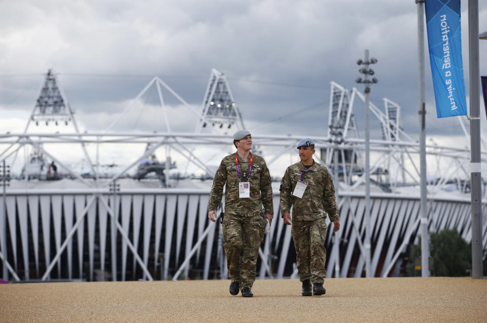 British military personnel walk away from the Olympic Stadium as preparations continue for the 2012 Summer Olympics, Sunday, July 15, 2012, in London. (AP Photo/Jae Hong)