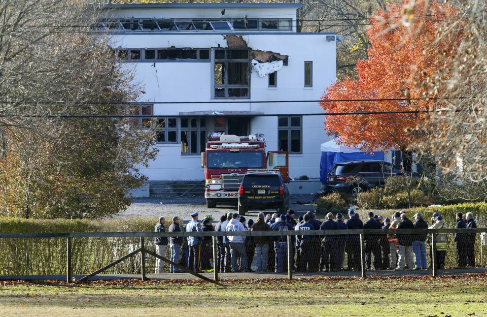 FILE - In this Nov. 21, 2018 file photo, authorities gather in Colts Neck, N.J., to investigate the aftermath of fatal fire that killed two children and two adults. The bodies of Keith Caneiro, his wife Jennifer Caneiro, their children Jesse, 11, and Sophia 8, were found at the scene: all victims of an apparent homicide. (AP Photo/Noah K. Murray, File)