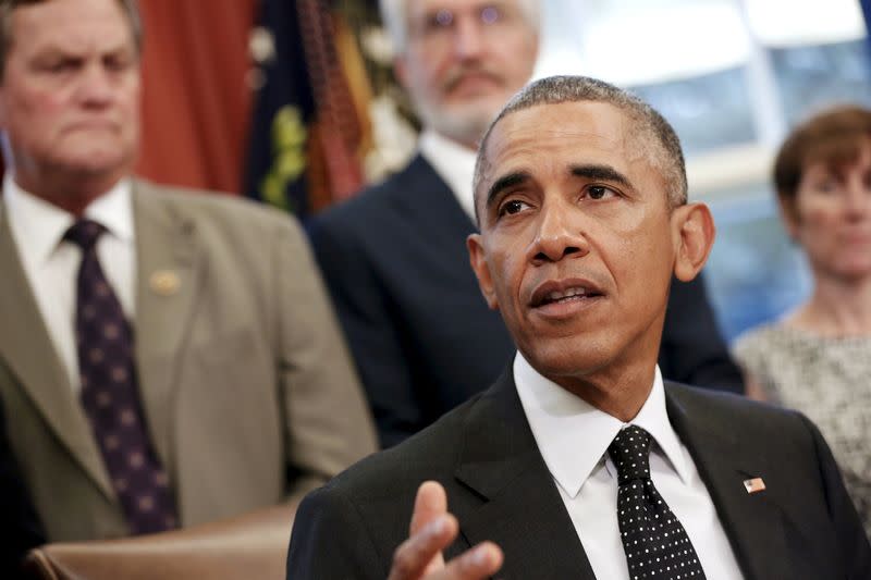 U.S. President Barack Obama, flanked by guest observers including U.S. Representative Mike Simpson (R-ID) (L), delivers remarks before signing the Sawtooth National Recreation Area and Jerry Peak Wilderness Additions Act into law at his desk in the Oval Office at the White House in Washington August 7, 2015.  REUTERS/Jonathan Ernst 