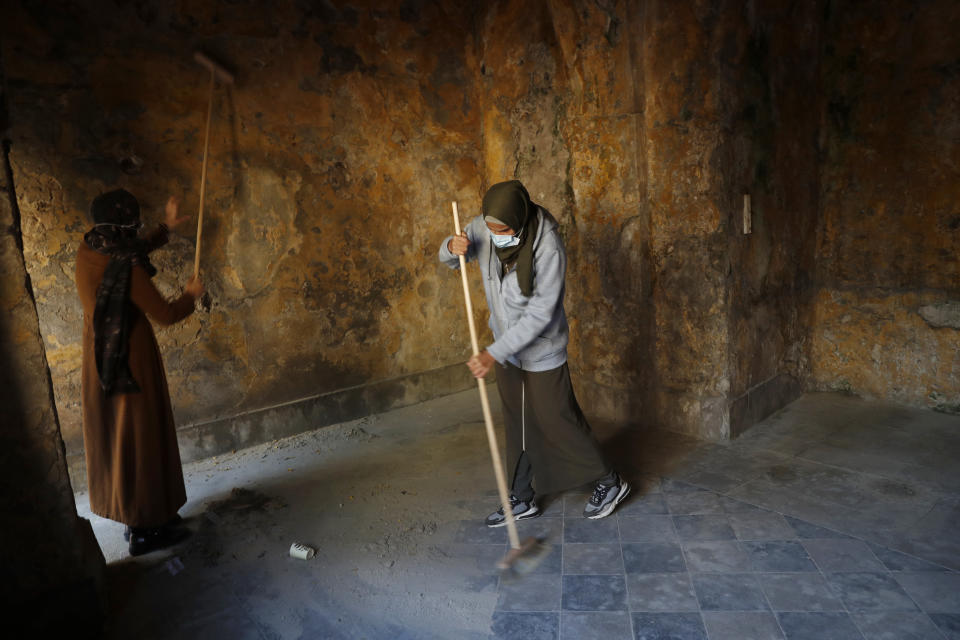 Female artist volunteers renovate a room of the long-abandoned 200-year-old al-Kamalaia school, in the old quarter of Gaza City, Sunday, Dec. 20, 2020. Less than 200 of these old buildings are still partly or entirely standing, according to officials and they are threatened by neglect, decaying and urban sprawl. (AP Photo/Adel Hana)