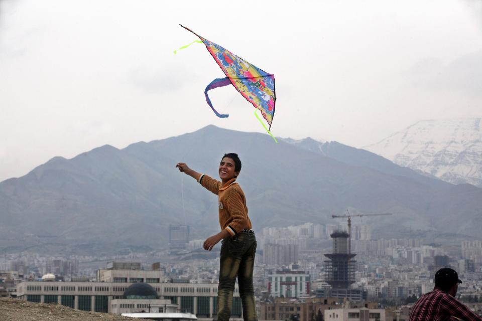 An Iranian boy flies a kite during the ancient festival of Sizdeh Bedar, an annual public picnic day on the 13th day of the Iranian new year, at Pardisan Park, in Tehran, Iran, Wednesday, April 2, 2014. Sizdeh Bedar, which comes from the Farsi words for “thirteen” and “day out,” is a legacy from Iran’s pre-Islamic past that hard-liners in the Islamic Republic never managed to erase from calendars. Many say it’s bad luck to stay indoors for the holiday. (AP Photo/Vahid Salemi)