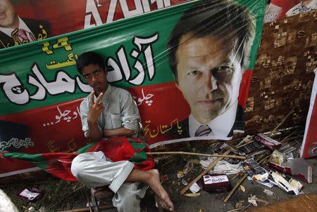 A supporter of Imran Khan, chairman of Pakistan Tehreek-e-Insaf (PTI) political party, gestures while sitting outside Khan's residence before the start of today's Freedom March in Lahore August 14, 2014. REUTERS/Akhtar Soomro