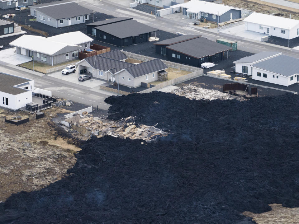 An areal view of the lava flow front in the town of Grindavik, Iceland, Monday, Jan. 15, 2024. Iceland's president says the country is battling "tremendous forces of nature" after molten lava from a volcano consumed several houses in the evacuated town of Grindavik. (AP Photo/ Marco Di Marco)
