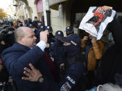 Police separate protesting women's rights activists from a member of Ordo Iuris, a conservative anti-abortion organization in Warsaw, Poland, Sunday, Oct. 25, 2020. Protests took part in churches Sunday by women angry about new restrictions on Poland's already strict abortion law.(AP Photo/Czarek Sokolowski)