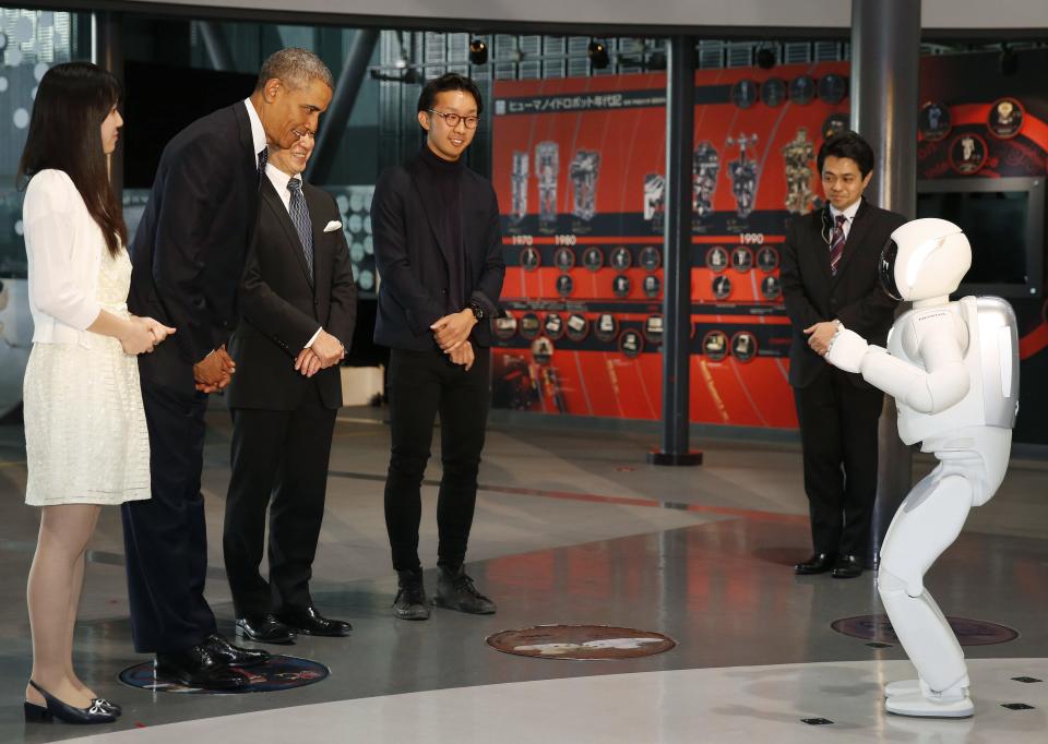 U.S. President Barack Obama bows to "Asimo" the robot while visiting Miraikan in Tokyo