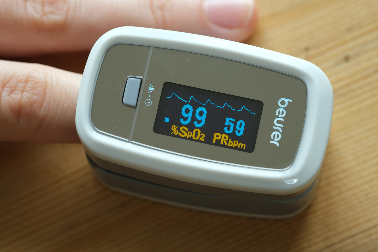 BERLIN, GERMANY - APRIL 28: In this photo illustration, a young woman uses an oximeter to measure her pulse and her peripheral oxygen saturation level during the coronavirus crisis on April 28, 2020 in Berlin, Germany. The device is useful in checking for low or declining oxygen saturation, which might indicate onsetting pneumonia, a common condition among Covid-19 patients who wind up in intensive care.   (Photo by Sean Gallup/Getty Images)