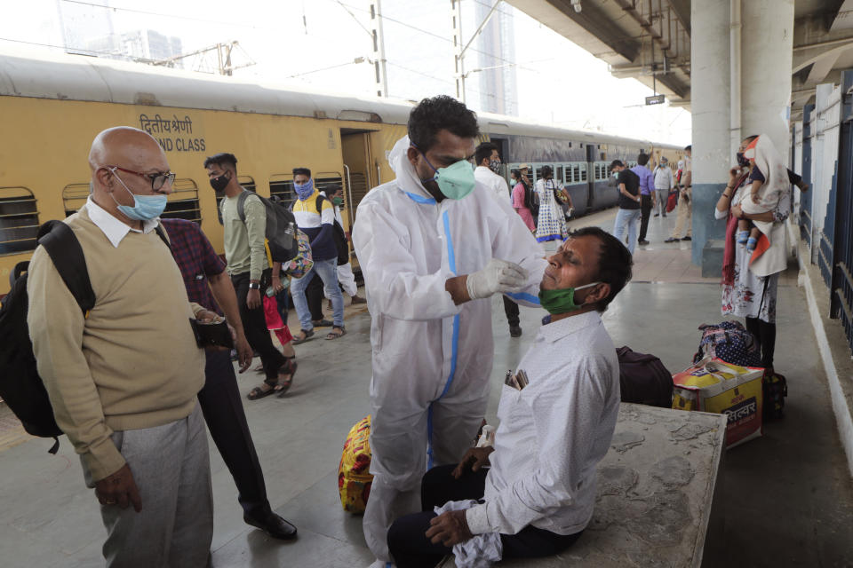 A health worker takes a swab sample of a commuter to test for COVID-19 at a train station in Mumbai, India, Thursday, Feb. 11, 2021. When the coronavirus pandemic took hold in India, there were fears it would sink the fragile health system of the world’s second-most populous country. Infections climbed dramatically for months and at one point India looked like it might overtake the United States as the country with the highest case toll. But infections began to plummet in September, and experts aren’t sure why. (AP Photo/Rajanish Kakade)