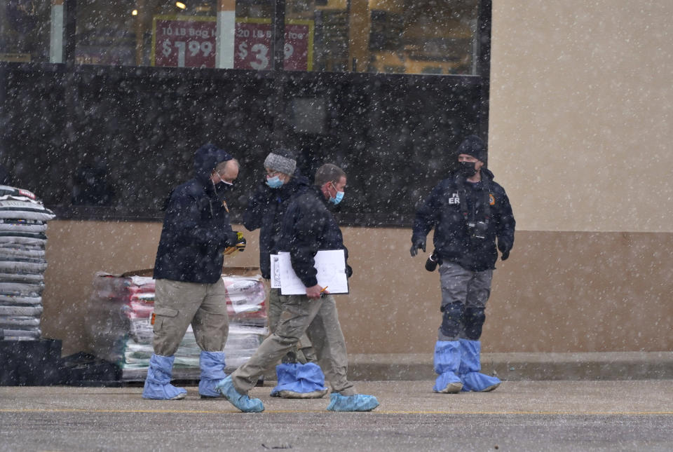Investigators deal with light snow as they collect evidence in the parking lot where a mass shooting took place in a King Soopers grocery store Tuesday, March 23, 2021, in Boulder, Colo. (AP Photo/David Zalubowski)