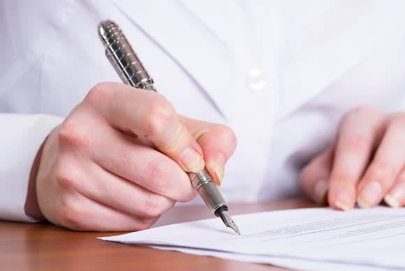 Man writing on document with pen