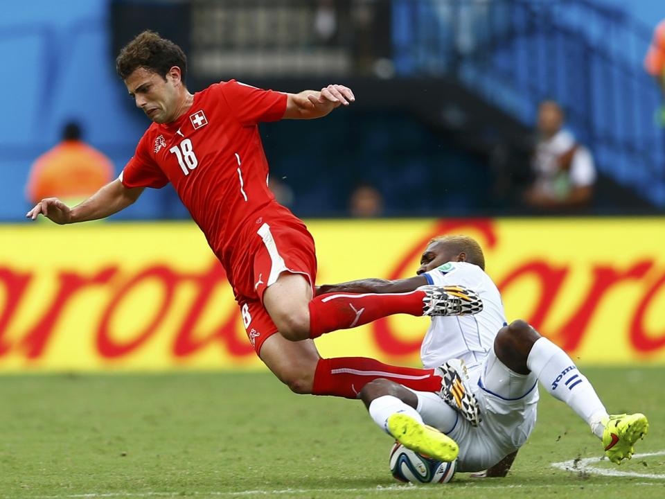 Brayan Beckeles (R) of Honduras tackles Switzerland's Admir Mehmedi during their 2014 World Cup Group E soccer match at the Amazonia arena in Manaus June 25, 2014. REUTERS/Dominic Ebenbichler (BRAZIL - Tags: SOCCER SPORT WORLD CUP)