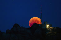 <p>The moon turns red during a total lunar eclipse, behind the Saentis in Luzern, Switzerland, Friday, July 27, 2018. (Photo: Christian Merz/Keystone via AP) </p>