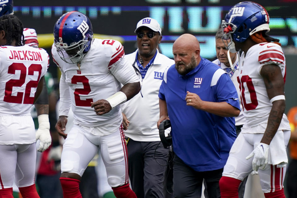 New York Giants quarterback Tyrod Taylor (2) runs off the field alongside head coach Brian Daboll, center right, after taking a hard hit from New York Jets defensive end Micheal Clemons (72) in the first half of a preseason NFL football game, Sunday, Aug. 28, 2022, in East Rutherford, N.J. (AP Photo/Julia Nikhinson)