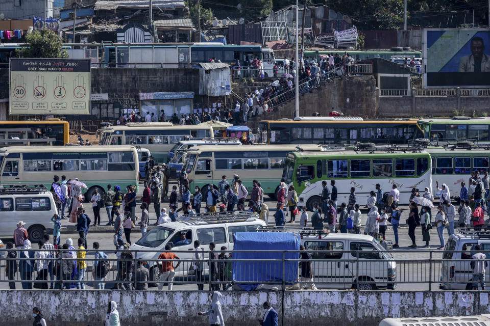 Passengers queue to get on buses in the capital Addis Ababa, Ethiopia Friday, Nov. 6, 2020. Ethiopia's prime minister says airstrikes have been carried out against the forces of the country's Tigray region, asserting that the strikes in multiple locations "completely destroyed rockets and other heavy weapons." (AP Photo/Mulugeta Ayene)