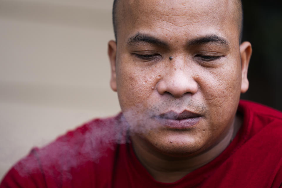 Seafarer Richard Zambales, from the Philippines, smokes outside a temporary rental house in Lacey, Wash., on Tuesday, Jan. 30, 2024. While waiting for backpay, stuck in the U.S., Zambales wasn’t sure he would be able to pay for his wife’s heart medication. (AP Photo/Lindsey Wasson)