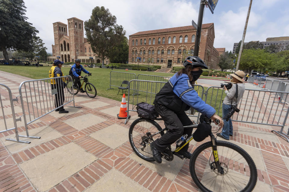 FILE - Security ride their bicycles around steel barriers blocking public access around Royce Hall area of the UCLA campus in Los Angeles on Friday, May 3, 2024. Colleges and universities have long been protected places for free expression without pressure or punishment. But protests over Israel's conduct of the war in Gaza in its hunt for Hamas after the Oct. 7 massacre has tested that ideal around the world. (AP Photo/Damian Dovarganes, File)