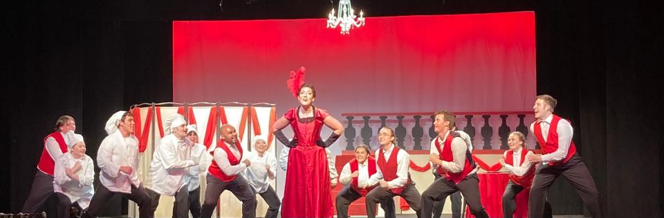 Bella Bosco as Dolly Levi being welcomed back by the staff of Harmonia Gardens  in a scene from "Hello, Dolly!" at College Light Opera Company in Falmouth.