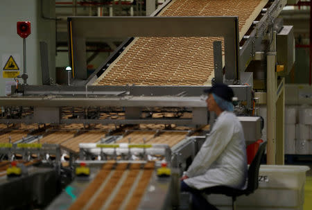 A worker inspects biscuits on the production line of Pladis' McVities factory in London Britain, September 19, 2017. Picture taken September 19, 2017. REUTERS/Peter Nicholls.