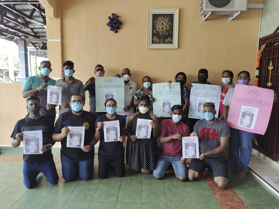 In this photo provided by Sarmila Dharmalingan, members of the family of Nagaenthran K. Dharmalingam including Sarmila, top right, hold posters with photos of Nagaenthran along with messages which read 'Save Nagaenthran' and 'Stop the Execution' in Ipoh, Malaysia, Monday, Nov. 8, 2021. Singapore's High Court has halted the imminent execution of Nagaenthran, believed to have a mental disability, amid pleas from the international community and rights groups. The 33-year-old Malaysian man was due to be executed by hanging on Wednesday for trying to smuggle a small amount of heroin into the country — nearly 43 grams (1.5 ounces). (Sarmila Dharmalingam via AP)