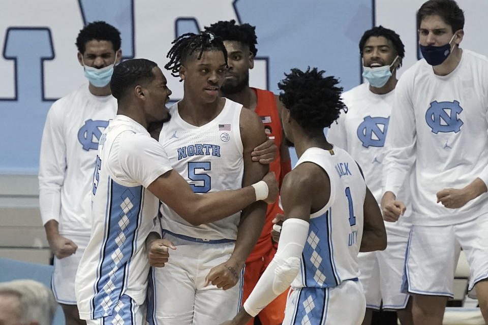 North Carolina forward Garrison Brooks, left, celebrates with forward Armando Bacot (5) and guard Leaky Black (1) following Bacot's basket against Syracuse during the second half of an NCAA college basketball game in Chapel Hill, N.C., Tuesday, Jan. 12, 2021. (AP Photo/Gerry Broome)