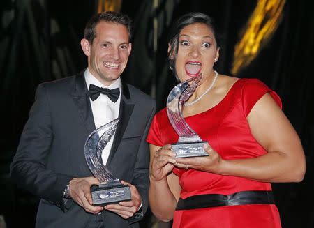 Shot putter Valerie Adams of New Zealand (R) poses with World-record pole vaulter Renaud Lavillenie of France (L) after receiving their 2014 IAAF Athletes of the Year trophies during the IAAF Gala in Monte Carlo November 21, 2014. REUTERS/Eric Gaillard