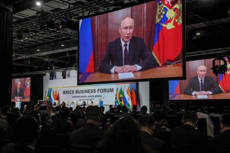 Vladimir Putin, president of Russia, speaks by way of videotaped message on the first day of the BRICS summit at Sandton Convention Center on Tuesday in Johannesburg, South Africa. For war crimes in Ukraine, Putin faces an active warrant for his arrest by the International Criminal Court -- of which South Africa is a member. Photo by Jemal Countess/UPI