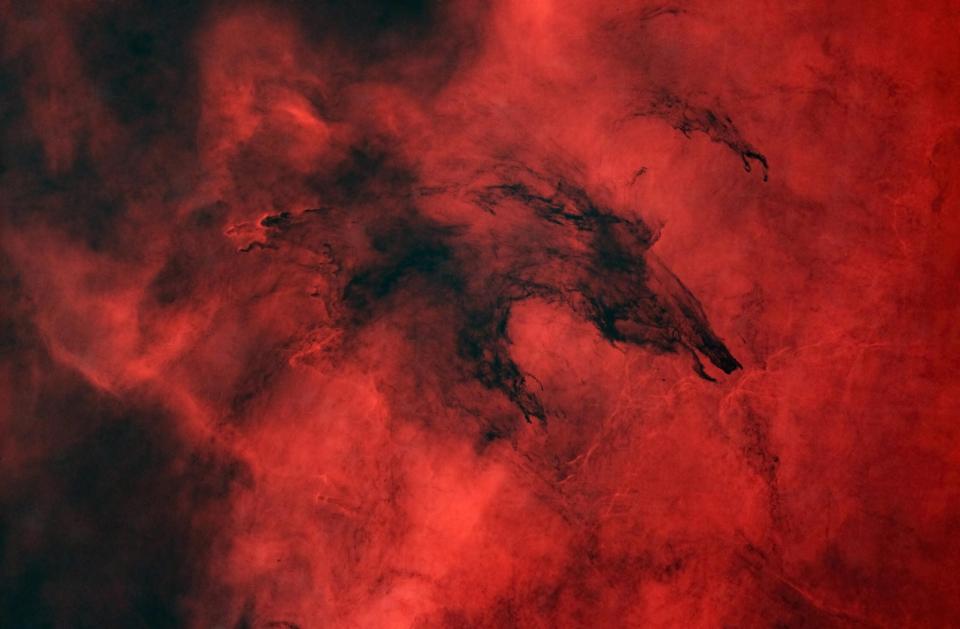 Thick black molecular cloud on a red hydrogen gas