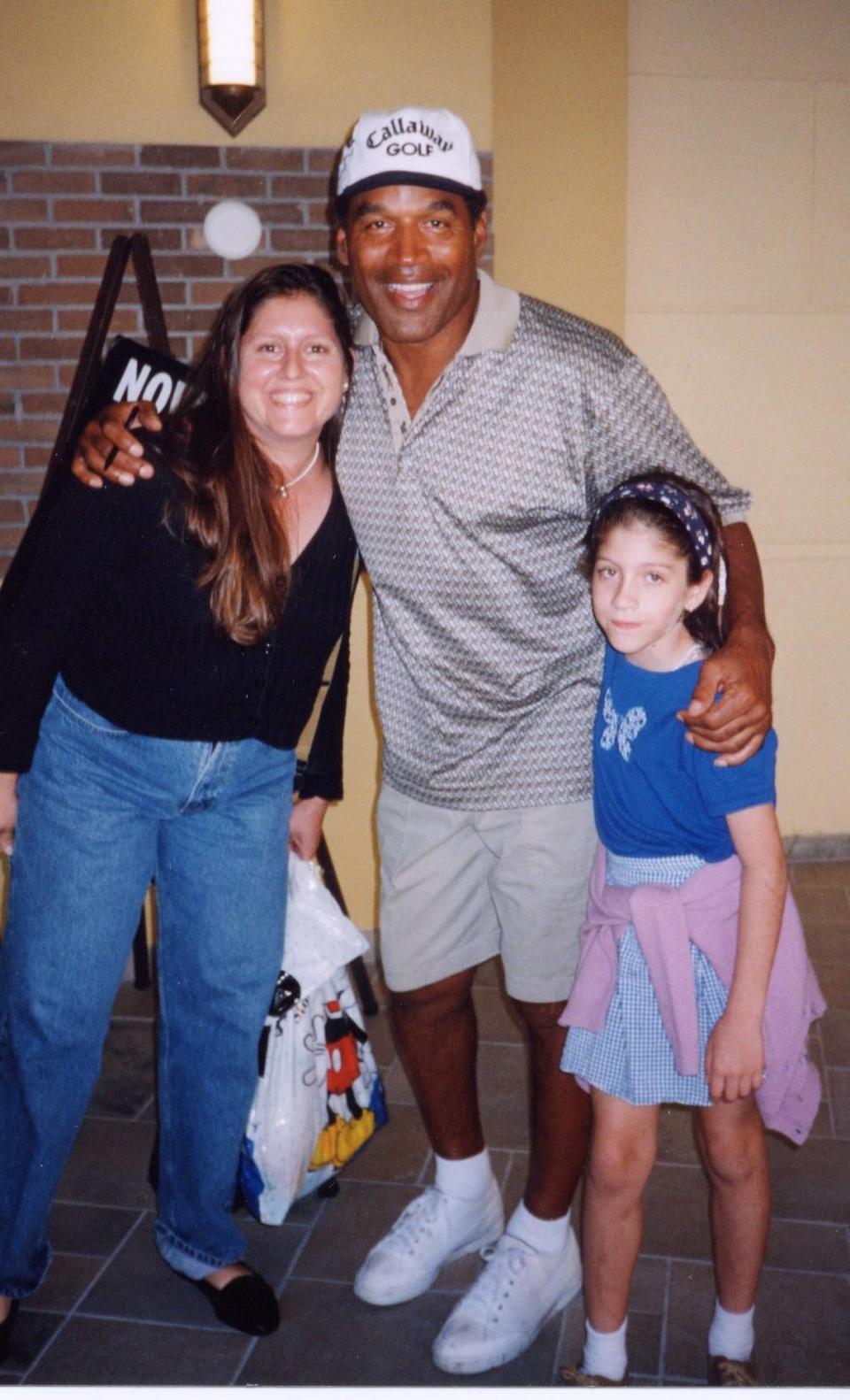 Teresita Gyori-Bosque y su hija, Carolyn Bosque, de 9 años, posan con O.J. SImpson en septiembre de 1999 después de que él y sus hijos comieran y jugaran en GameWorks, en South Miami.