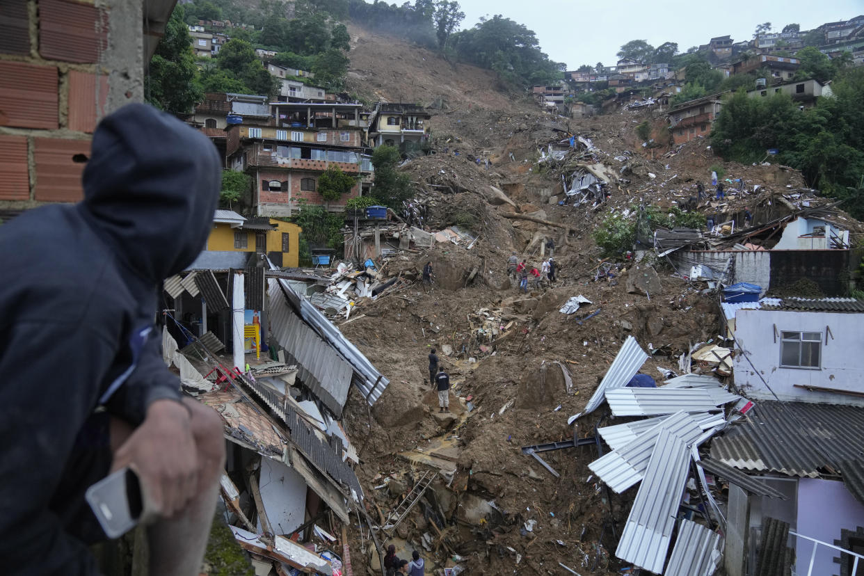 Rescue workers and residents search for victims in an area affected by landslides in Petropolis, Brazil, Wednesday, Feb. 16, 2022. Extremely heavy rains set off mudslides and floods in a mountainous region of Rio de Janeiro state, killing multiple people, authorities reported. (AP Photo/Silvia Izquierdo)