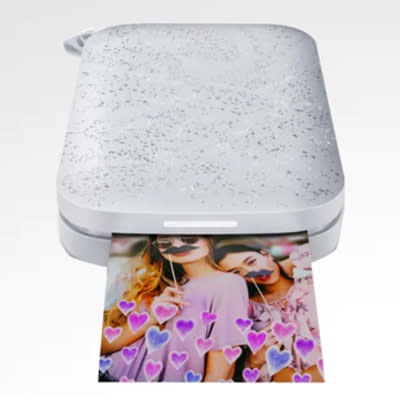 hp sprocket printer with a photo printing out on a white background