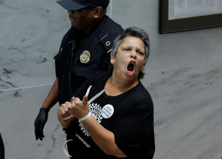 A protester is arrested during a demonstration in opposition to U.S. President Donald Trump's Supreme Court nominee Brett Kavanaugh and in support for Dr. Christine Blasey Ford, the woman who has accused Kavanaugh of sexual assault, on Capitol Hill in Washington, U.S., September 20, 2018. REUTERS/Yuri Gripas