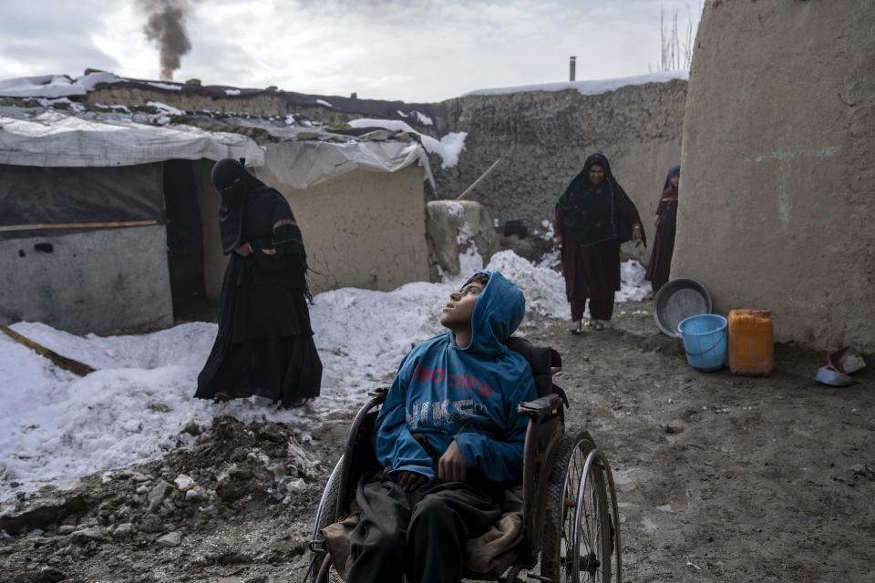 Rahmat, a 15-year-old disabled boy, is placed in the yard to get fresh air in a camp for internally displaced families on the outskirts of Kabul, Afghanistan, Monday, Jan 23, 2023. Since the chaotic Taliban takeover of Kabul on Aug. 15, 2021, an already war-devastated economy once kept alive by international donations alone is now on the verge of collapse. There isn't enough money for hospitals. The World Health Organization is warning of millions of children suffering malnutrition, and the U.N. says 97% of Afghans will soon be living below the poverty line. (AP Photo/Ebrahim Noroozi)