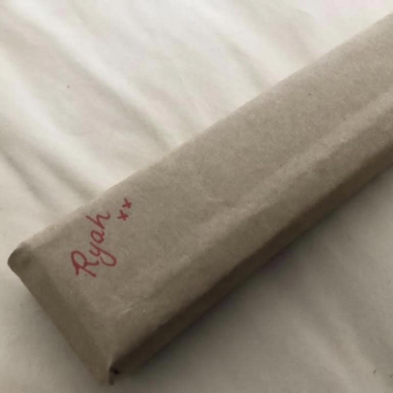 A rectangular Christmas present wrapped in brown paper with the name 'Ryah' written in red pen. Photo: Facebook.