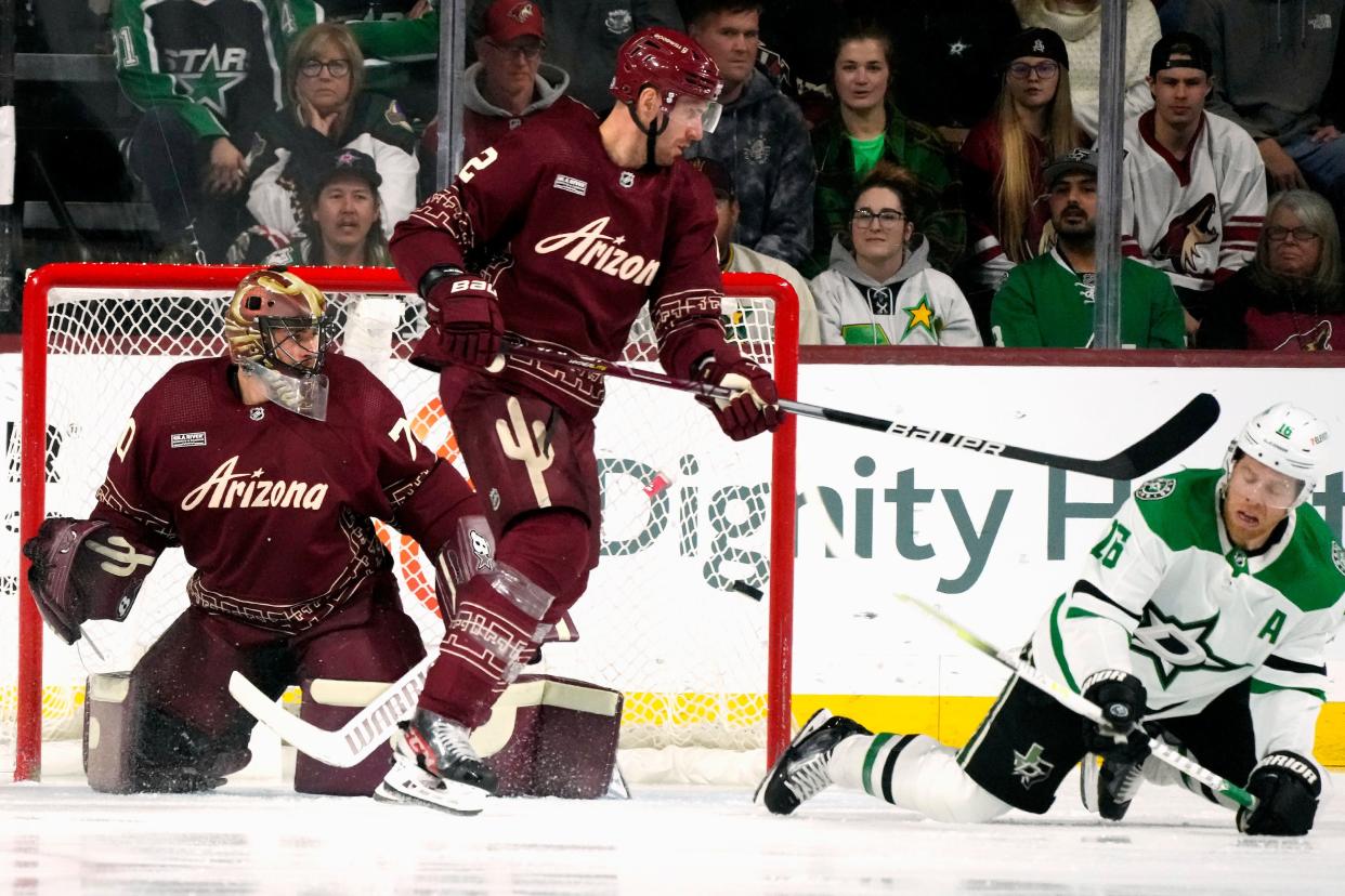 Dallas Stars center Joe Pavelski (16) redirects the puck past Arizona Coyotes defenseman Patrik Nemeth (2) and Coyotes goaltender Karel Vejmelka, left, for a goal during the first period of an NHL hockey game Friday, March 31, 2023, in Tempe, Ariz. (AP Photo/Ross D. Franklin)