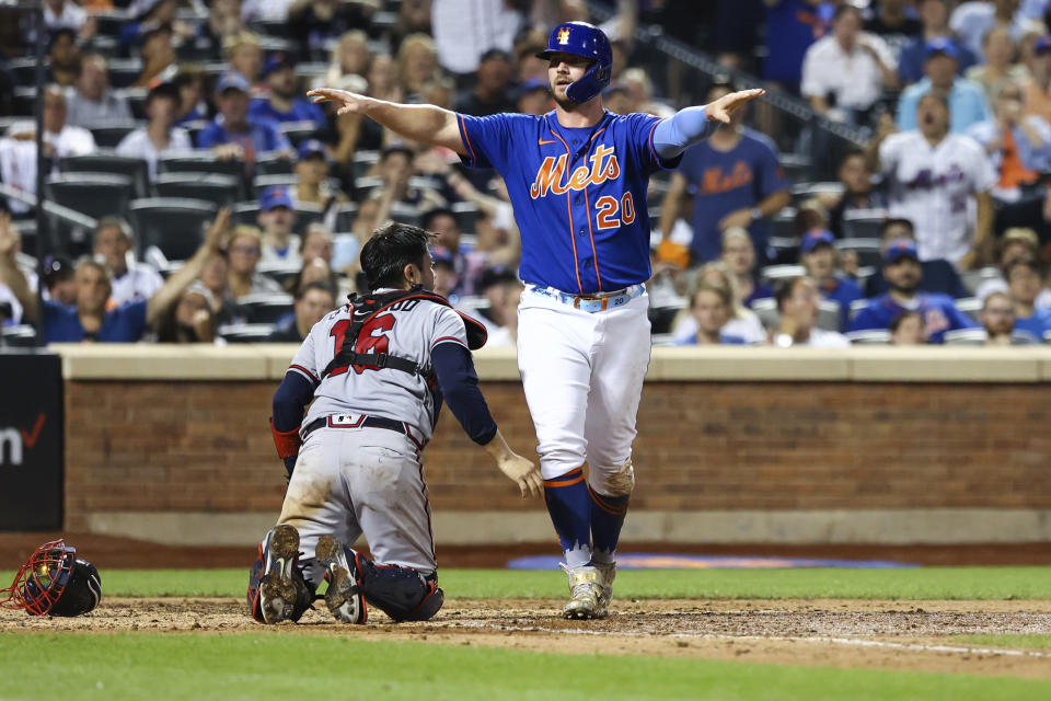 New York Mets' Pete Alonso (20) gestures after getting initially called out at home plate as Atlanta Braves catcher Travis d'Arnaud (16) watches during the sixth inning of the second game of a baseball doubleheader on Saturday, Aug. 6, 2022, in New York. Alonso was ruled safe after a challenge. (AP Photo/Jessie Alcheh)