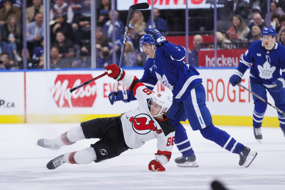 New Jersey Devils center Jack Hughes (86) and Toronto Maple Leafs right wing Pontus Holmberg (29) collide during the second period of an NHL hockey game Tuesday, March 26, 2024, in Toronto. (Cole Burston/The Canadian Press via AP)