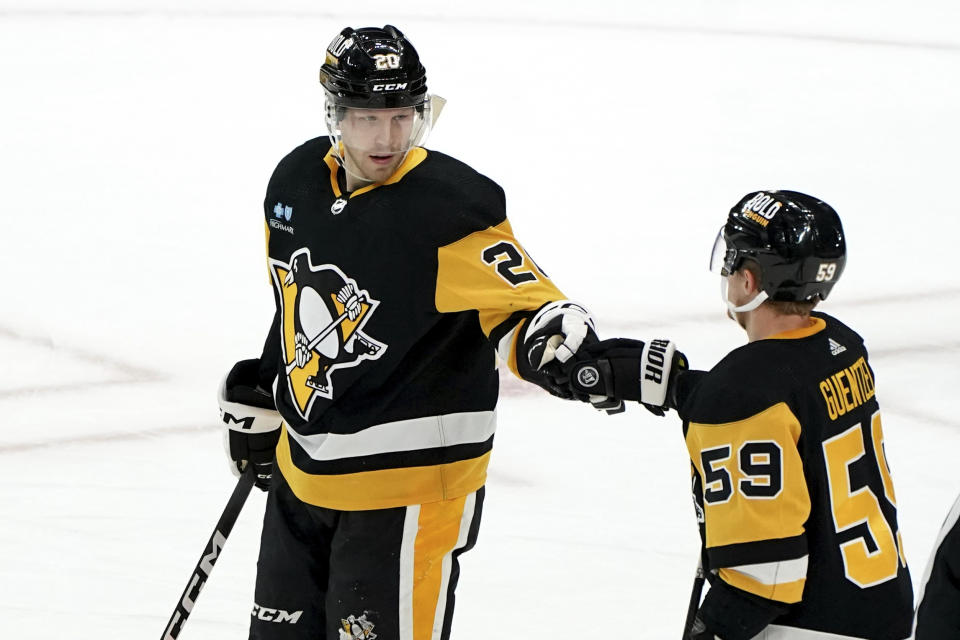 Pittsburgh Penguins' Lars Eller (20) celebrates with Jake Guentzel (59) after scoring against the New York Islanders during the third period of an NHL hockey game Sunday, Dec. 31, 2023, in Pittsburgh. (AP Photo/Matt Freed)