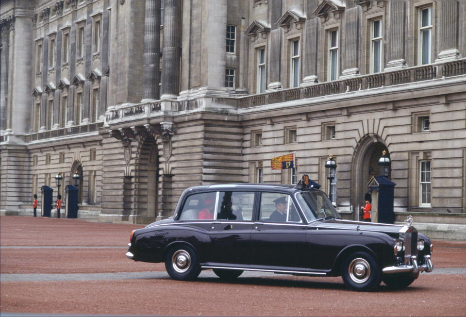 LONDON, UNITED KINGDOM - JANUARY 01:  Queen Elizabeth II Phantom Vi Rolls Royce Official Car Given To Her As A Gift For Her Silver Jubilee Returning To Buckingham Palace After An Official Engagement Driven By A Chauffeur With The Queen Sitting In The Back Circa 1990s. The Standard For The Queen Is In Position.  (Photo by Tim Graham Photo Library via Getty Images)