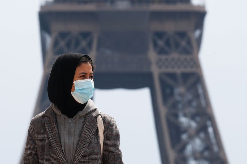 A woman wearing a hijab walks at Trocadero square near the Eiffel Tower in Paris