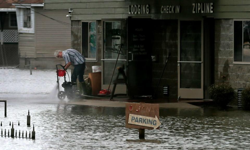 Handyman Jim Crow cleans an Aerie's Zipline building on Wednesday, June 19, 2019, in along Main Street in Grafton, Ill. On Wednesday, the level of the Mississippi River was 30.2 feet, having dropped about five feet from its crest at 35.17 on June 7. (Photo: Laurie Skrivan/St. Louis Post-Dispatch via AP)