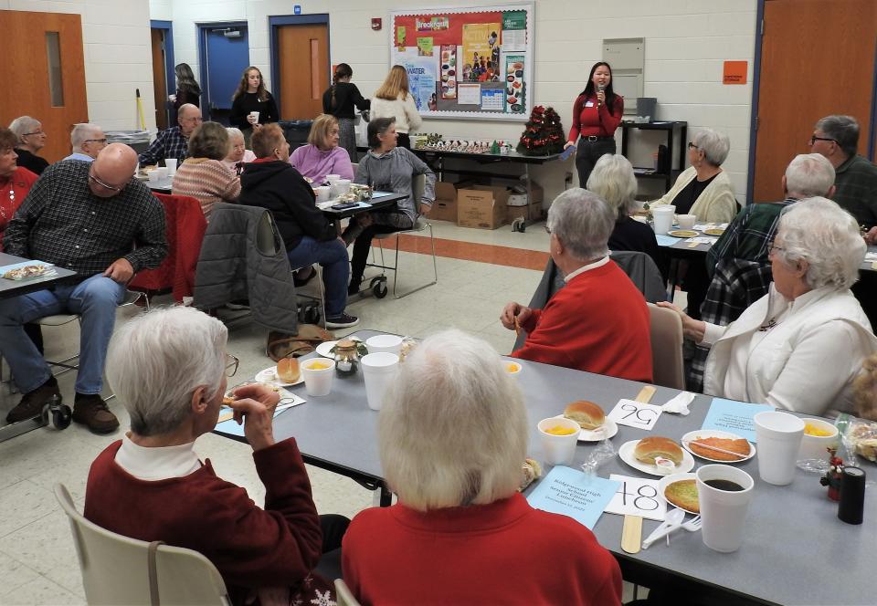 Senior Class President Aliyah Beitzel addresses about 120 senior citizens in attendance for annual luncheon honoring elders in the community at Ridgewood High School. Students made door prizes and table centerpieces and helped to serve meals and drinks.